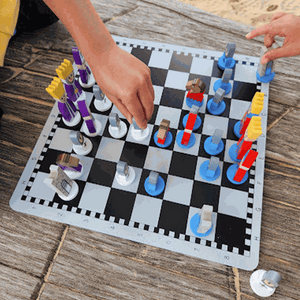 Educational wooden cartoon chess set for kids with colorful, playful pieces on a black and white board.